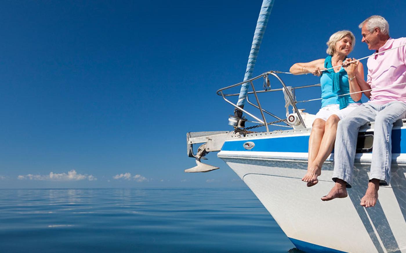 Older couple embracing on a boat overlooking a body of water